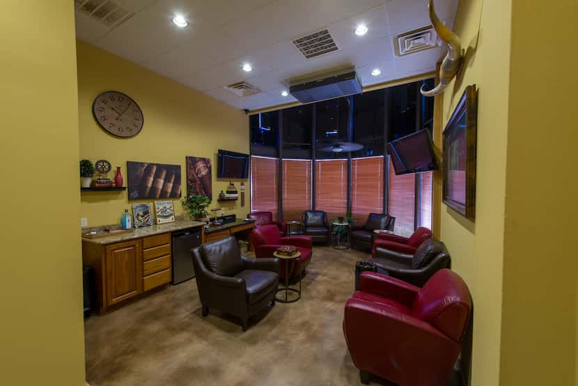 Renegade Cigars' member lounge has maroon and brown lounge chairs and yellow walls.