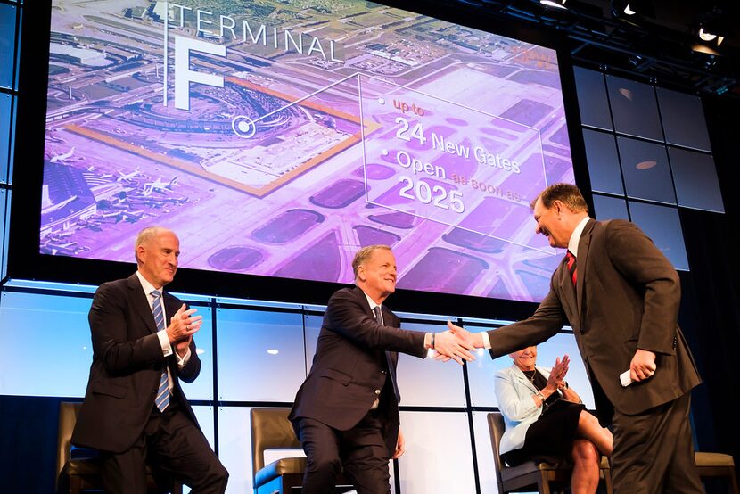 Dallas Mayor Mike Rawlings (right) shakes hands with American Airlines CEO Doug Parker...