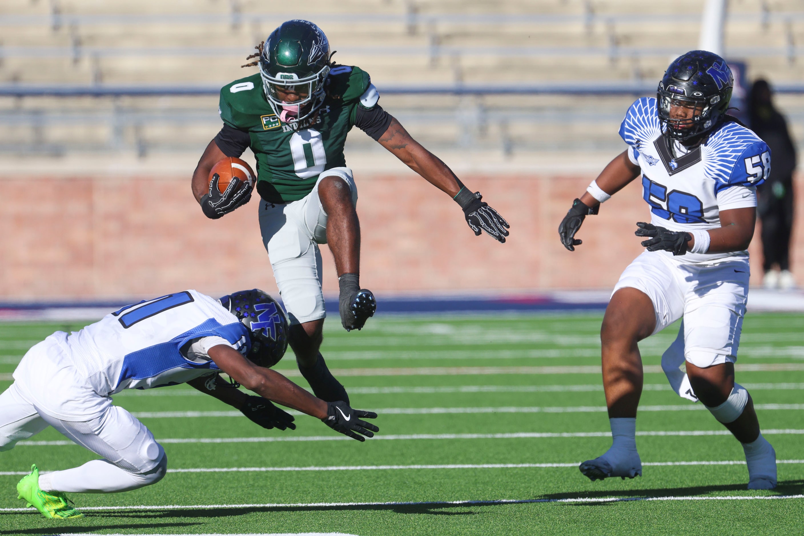 Waxahachie High’s Bryson Linnear (center) leaps over North Forney High’s Josiah Turner as he...