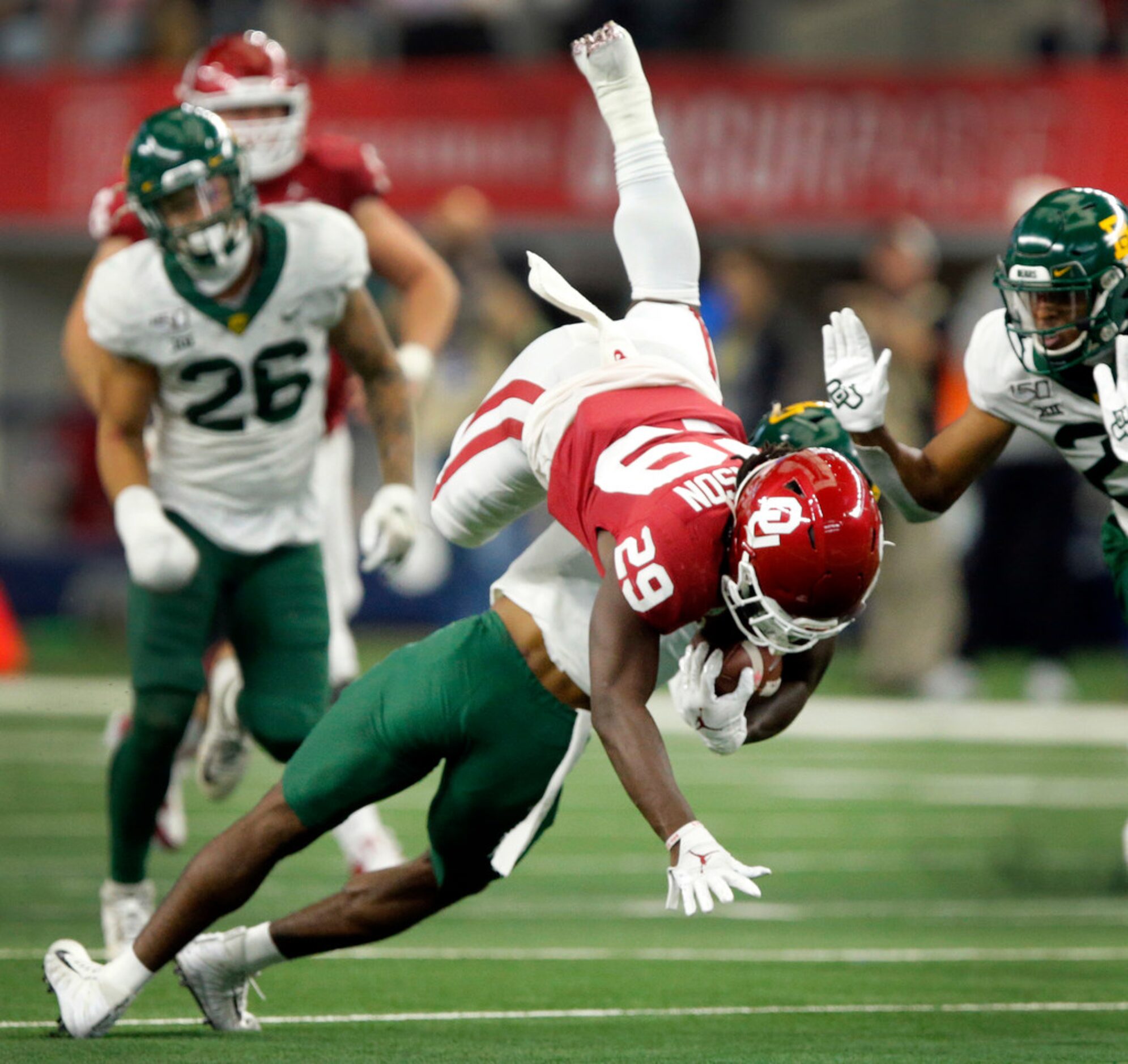 Baylor Bears safety Chris Miller (3) upends Oklahoma Sooners running back Rhamondre...