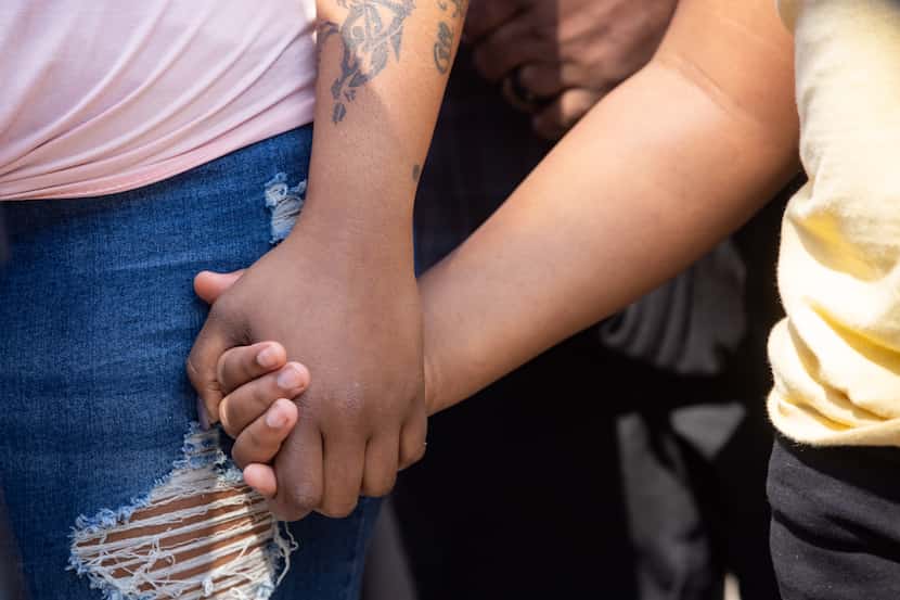Summer Smith holds her son's hand during a press conference in front of the Plano Police...