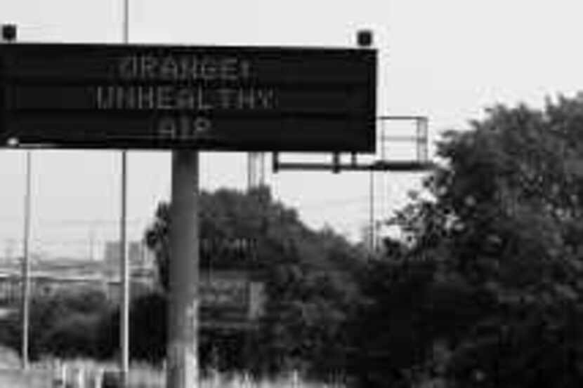  A highway sign alerts drivers on Interstate 35E to air pollution conditions. Such signs are...
