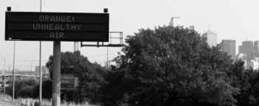  A highway sign alerts drivers on Interstate 35E to air pollution conditions. Such signs are...