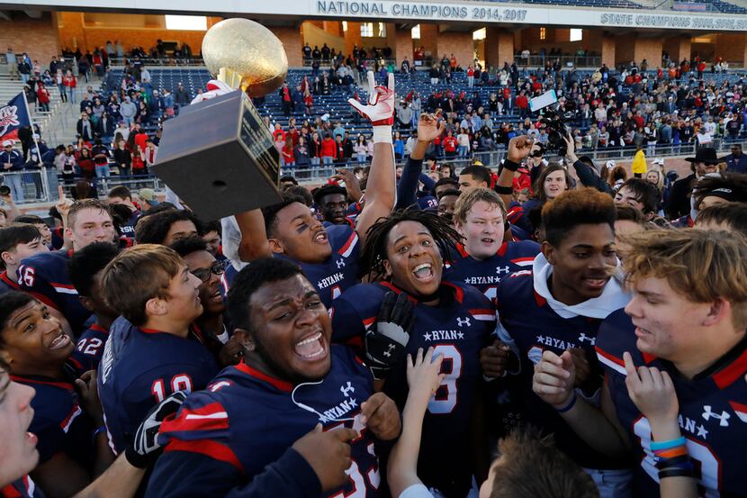 Denton Ryan's Ja'Tavion Sanders (1) holds up the state semifinal trophy after beating Frisco...
