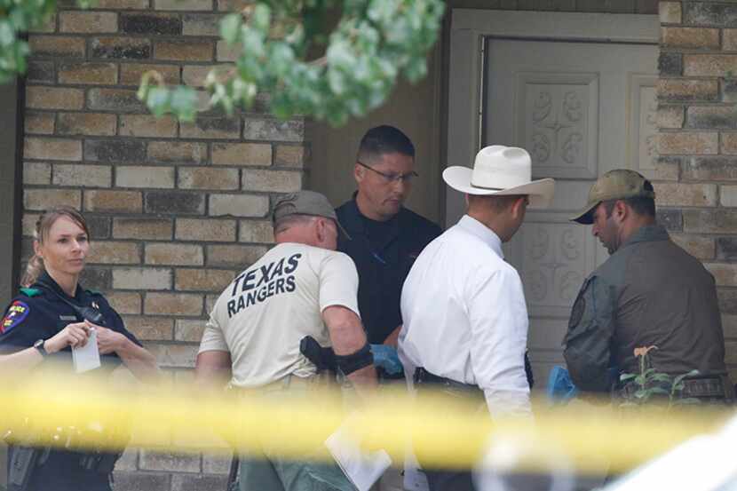 Plano police and Texas Rangers work the scene Monday morning at a house in Plano where seven...