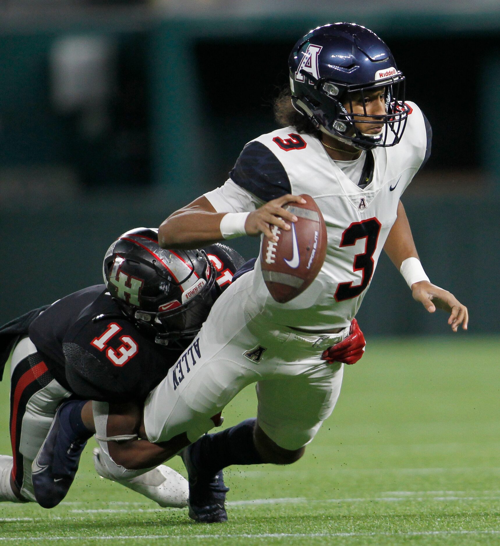 Allen quarterback Mike Hawkins (3) looks to pass as he is being tackled in the backfield by...