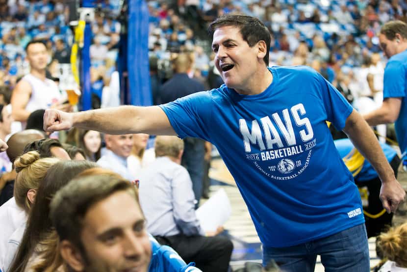 Dallas Mavericks owner Mark Cuban fist-bumps courtside fans before a game last fall at...