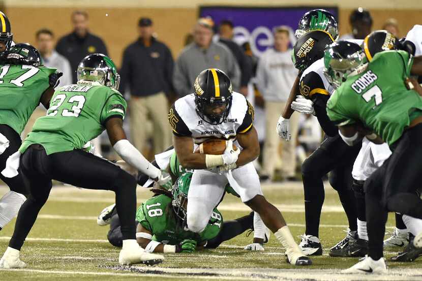 Southern Mississippi junior running back Ito Smith (25) gets tangled up by North Texas...