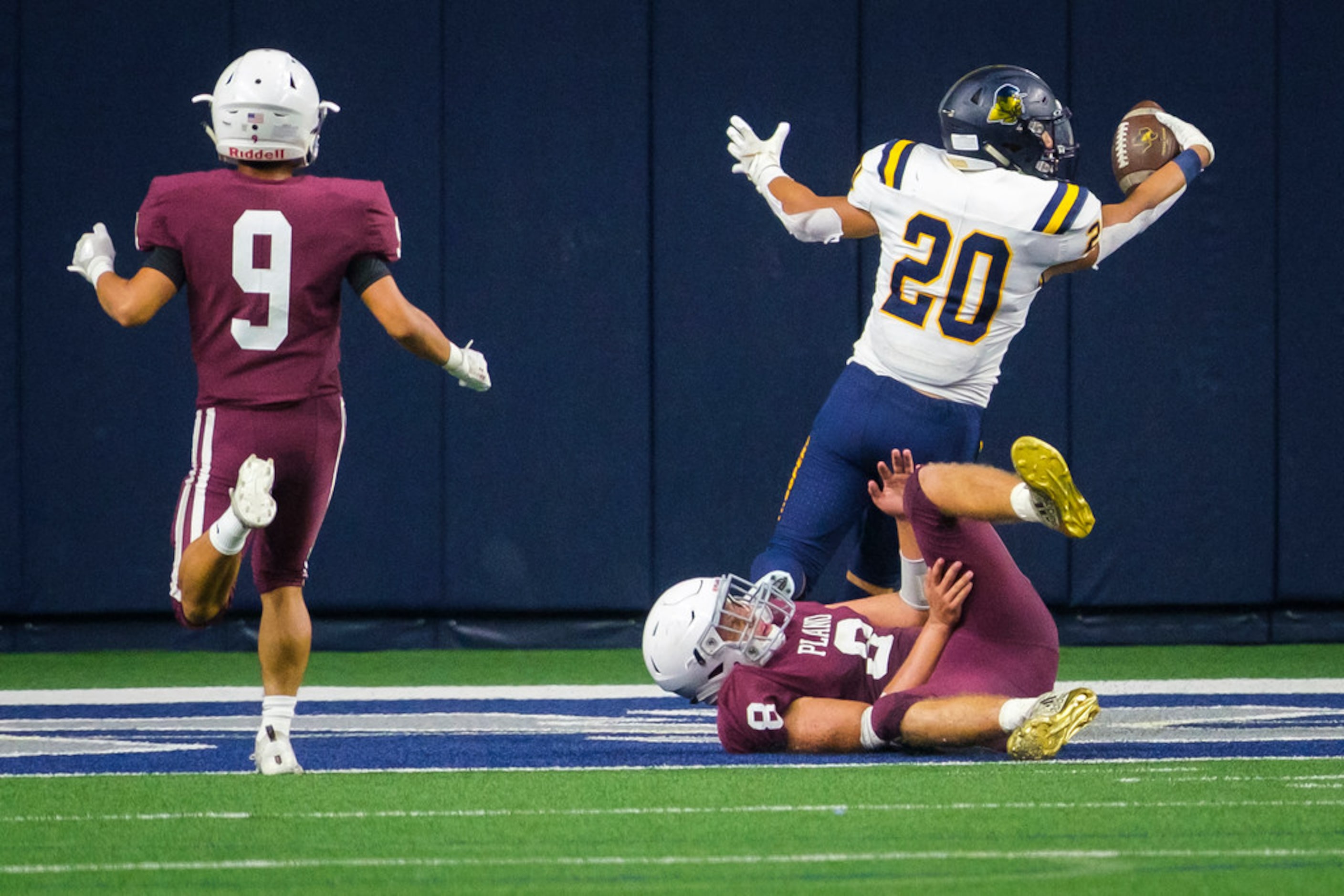 El Paso Eastwood running back Luca Gandara (20) scores past Plano linebacker Gavin Brand (8)...