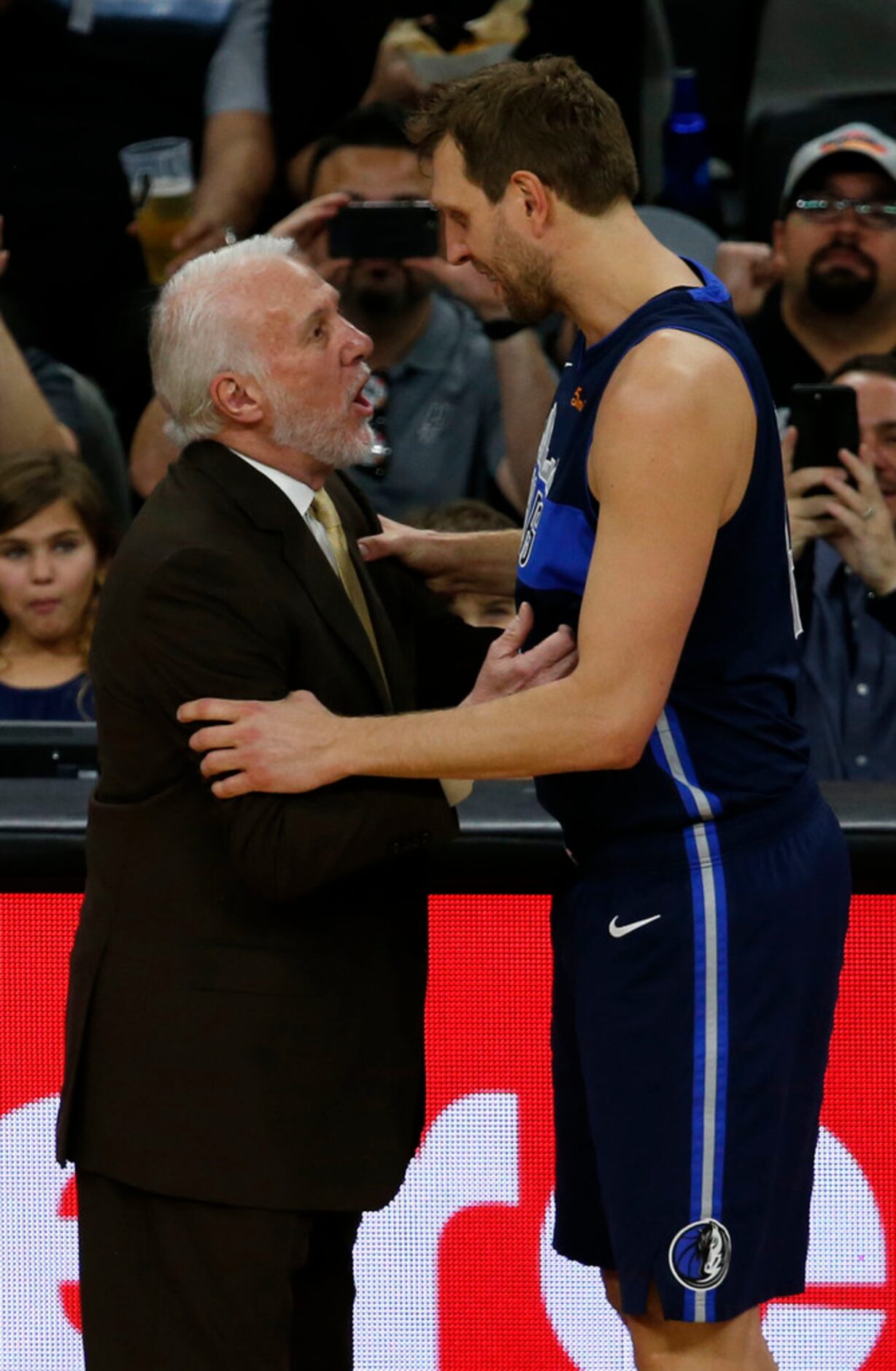 San Antonio Spurs head coach Gregg Popovich talks with Dallas Mavericks forward Dirk...