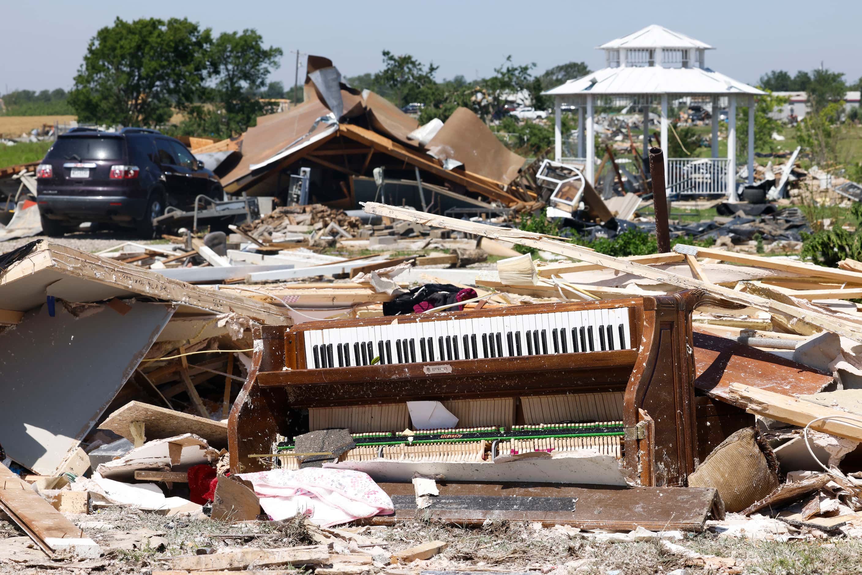 A damaged piano remains within other debris collected after a tornado moved through the area...