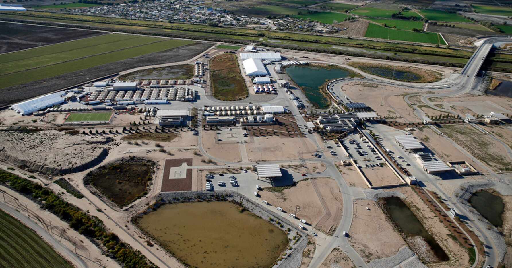 An aerial view of the tent city, at the left, near the U.S. Customs and Border Protection -...