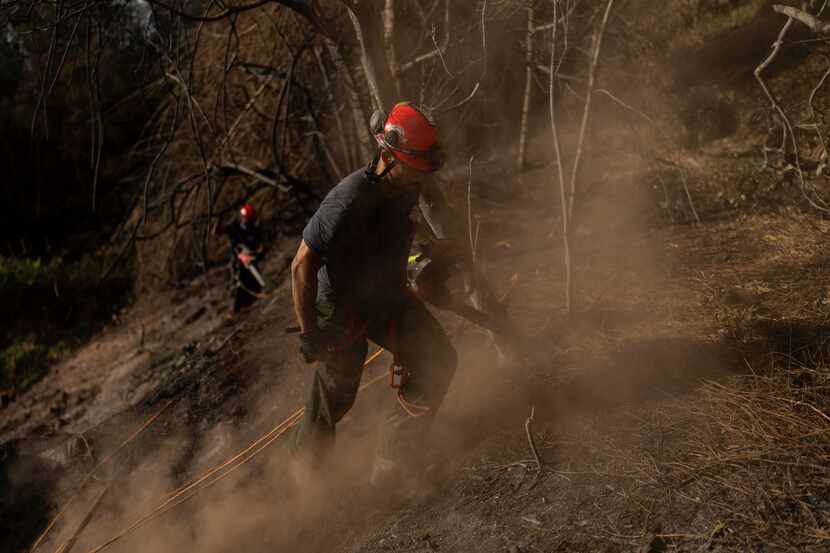 Firefighters clear debris in Kula, Hawaii, Tuesday, Aug. 15, 2023, following wildfires that...