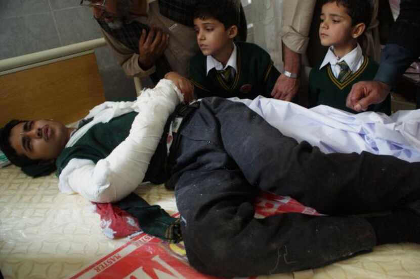 An injured Pakistani student lies on a bed at a hospital following an attack by Taliban...