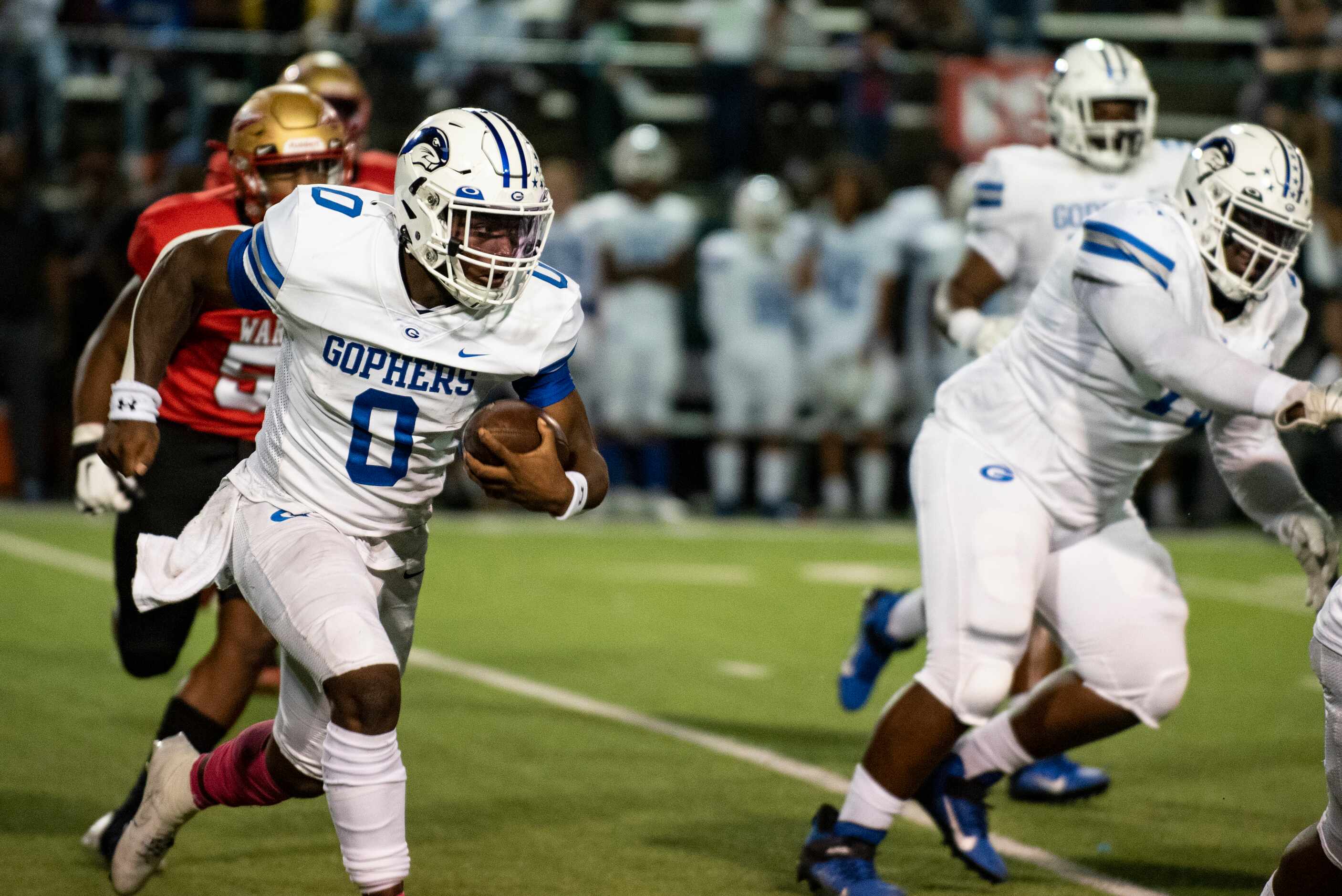 Grand Prairie senior Savion Red (0) looks to avoid defenders as he rushes down the field...