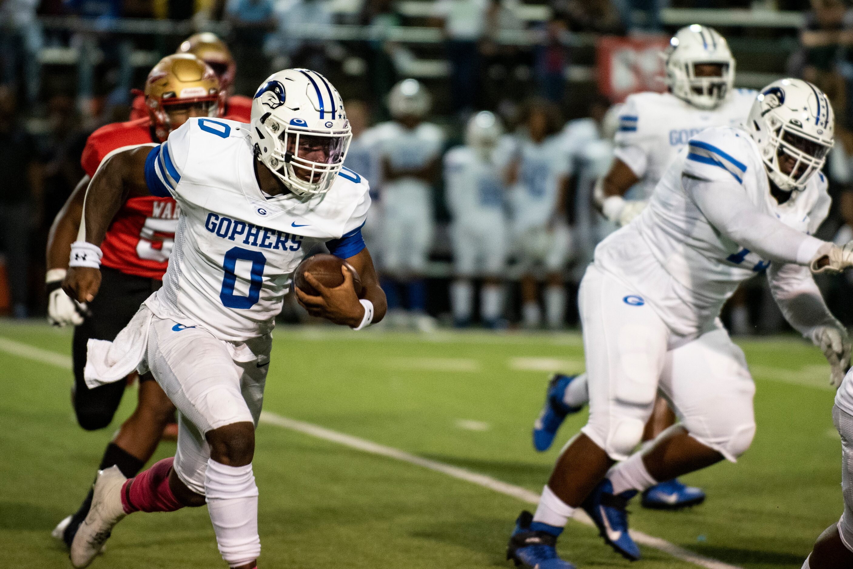 Grand Prairie senior Savion Red (0) looks to avoid defenders as he rushes down the field...