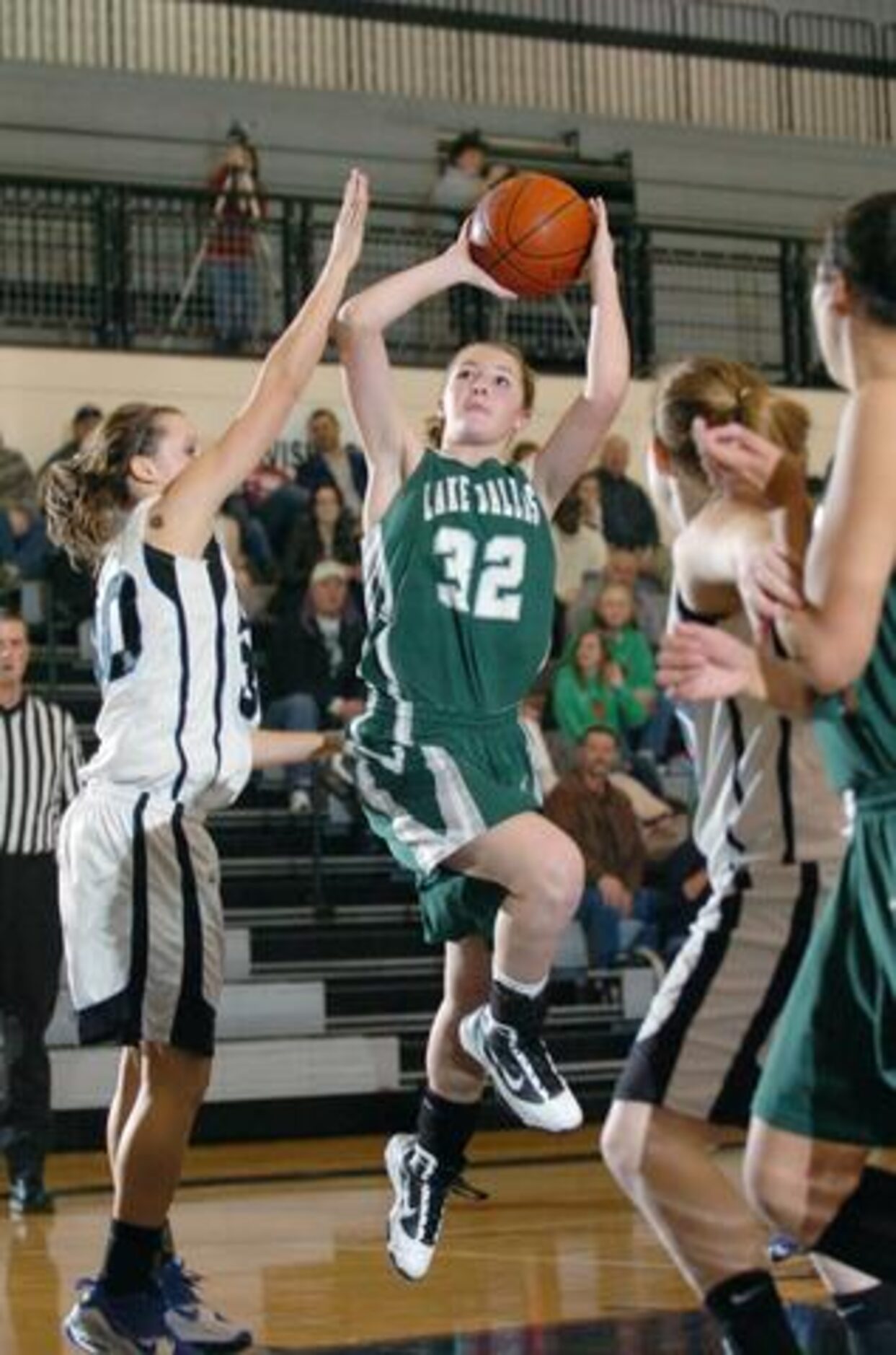 Lake Dallas' Megan Dando (32) goes up for a shot as Guyer's Kailey McEntire (30) tries to...