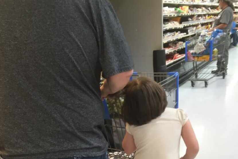 A young girl is pulled by her hair at a Wal-Mart in Cleveland, Texas. (Erika Burch)