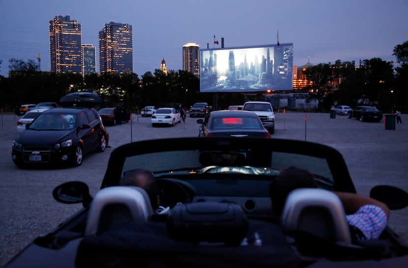 People watch the previews before the show while they visit the Coyote Drive-In in Fort...