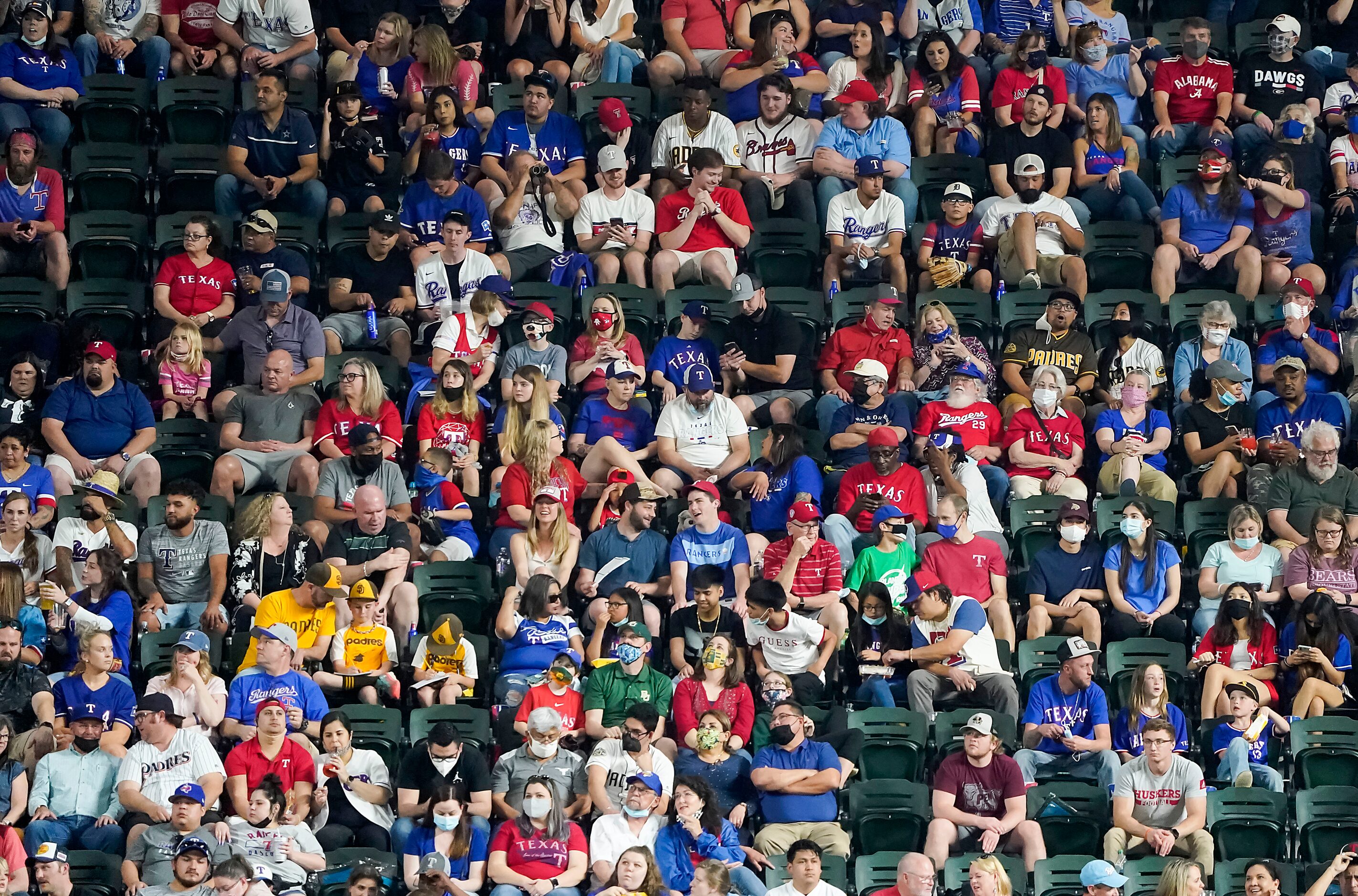 Fans in the right field seats watch the Texas Rangers face the San Diego Padres during the...