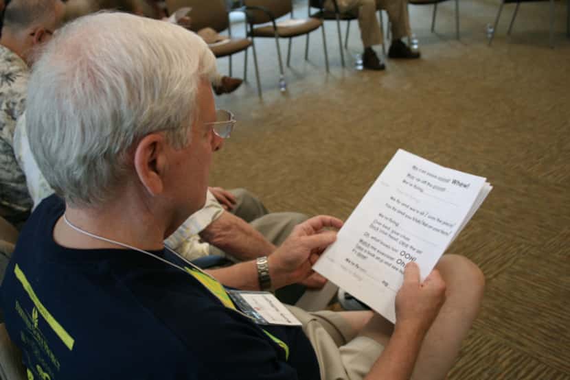 Monty Huffington reads along with other group members for a vocal exercise during a Loud...