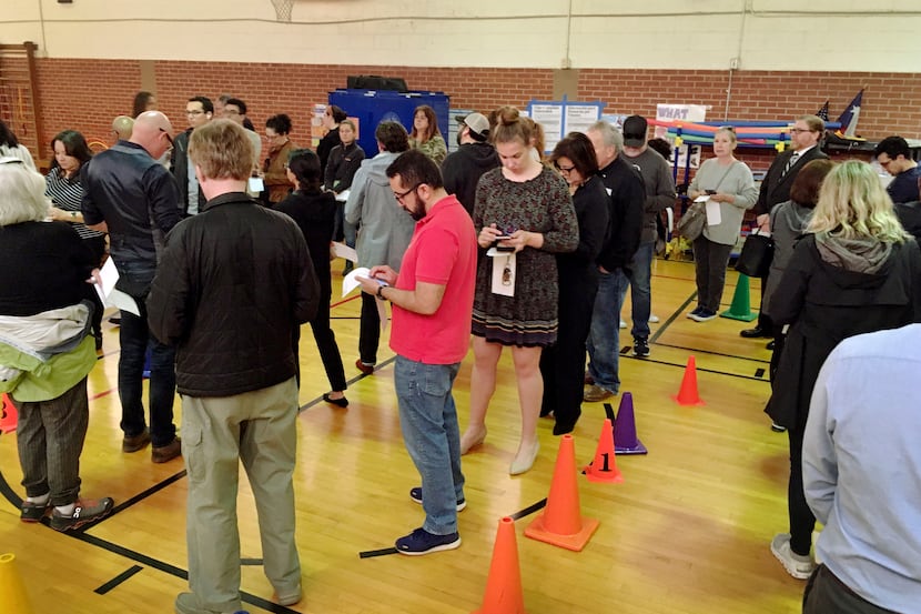 Voters in the Super Tuesday Democratic and Republican primaries line up to vote while...