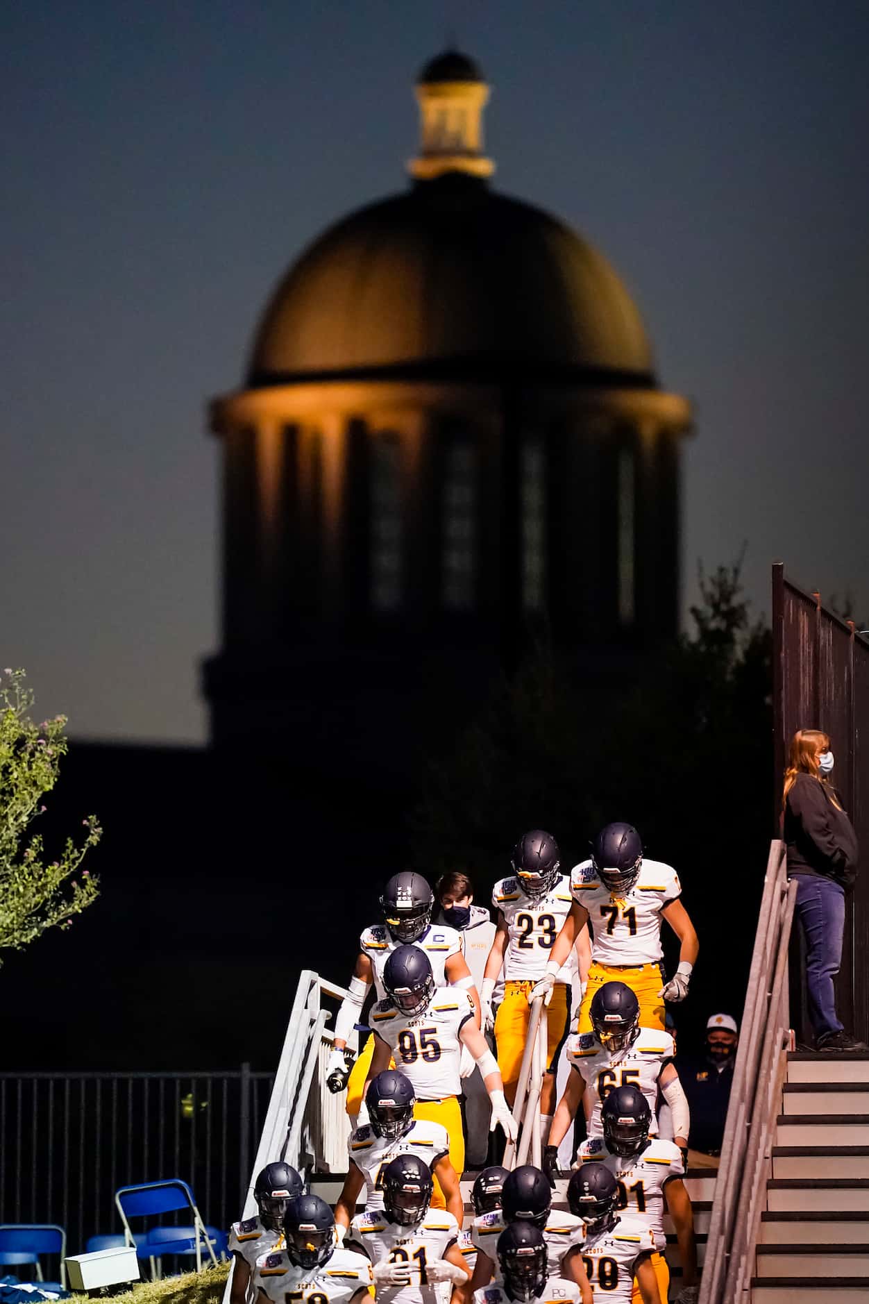 Highland Park players take the field as the Rockwall County Courthouse looms over them...
