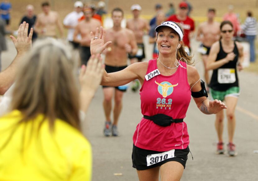 A runner gives high fives at the "high five station," near the 17 mile mark in the White...