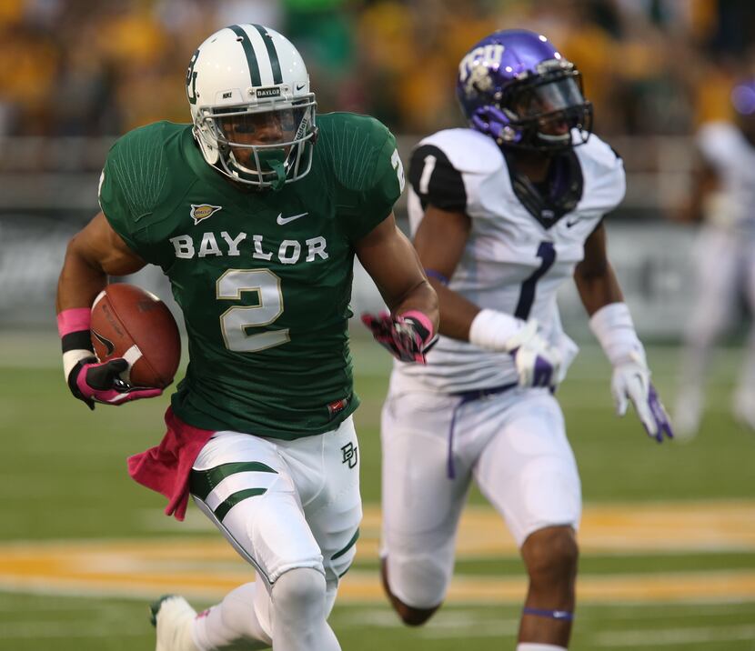 Baylor wide receiver Terrance Williams (2) runs past TCU safety Chris Hackett (1) for a...