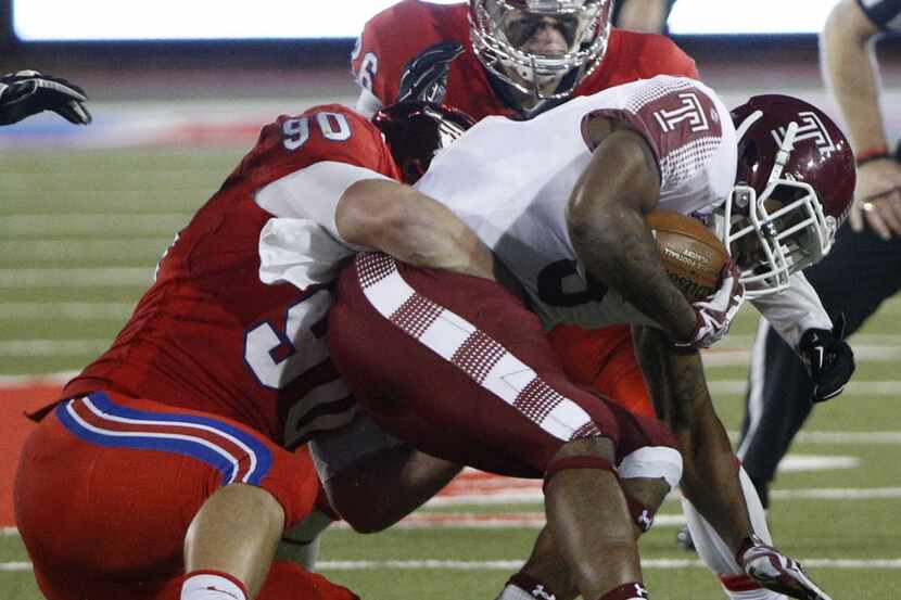 Southern Methodist Mustangs defensive end Zach Wood (90) and linebacker Jeremy White (16)...