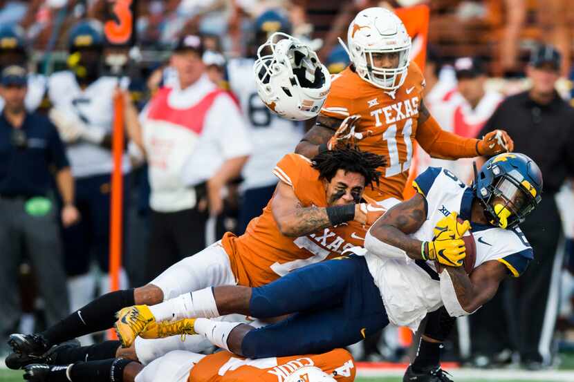 The hemet of Texas Longhorns defensive back Caden Sterns (7) flies off as he tackles West...