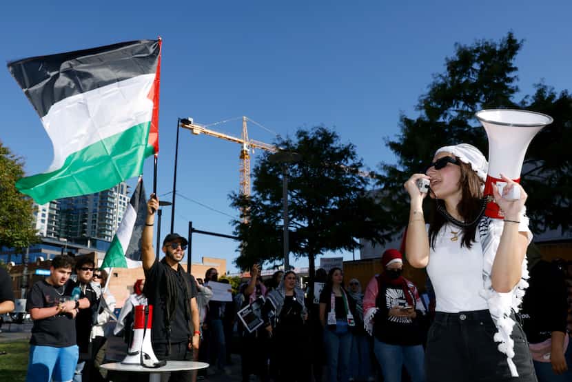 A woman leads a chant during a protest to end the siege in Gaza and media complicity...