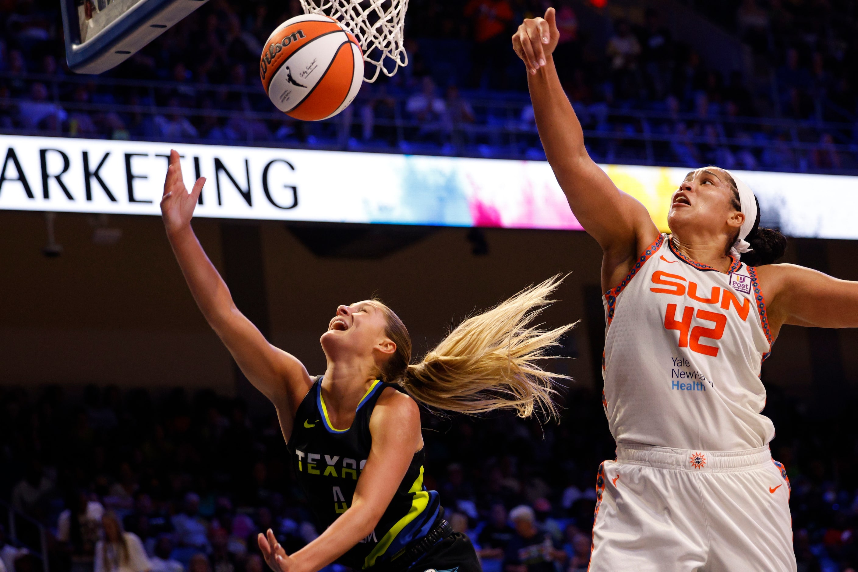 Dallas Wings guard Jacy Sheldon (4) tries to shoot as Connecticut Sun forward Brionna Jones...