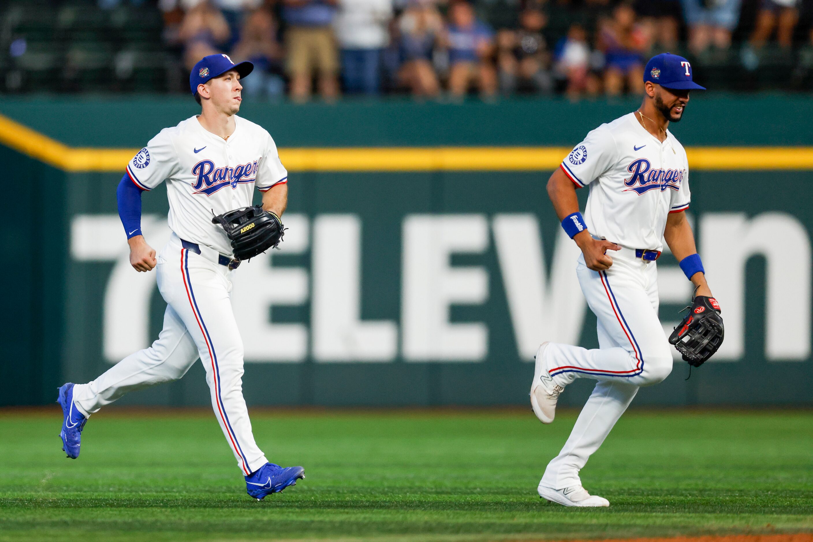 Texas Rangers left fielder Wyatt Langford (36) and center fielder Leody Taveras (3) jog to...