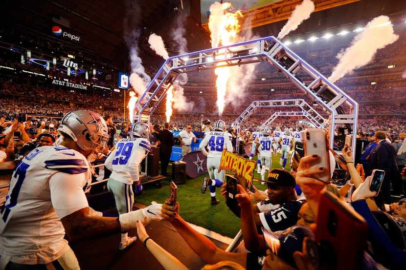 Dallas Cowboys outside linebacker Damien Wilson (57) slaps hands with fans as the team takes...