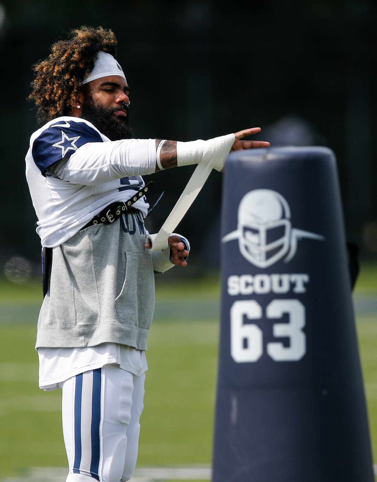 Dallas Cowboys running back Ezekiel Elliott (21) tapes his wrists during practice at The...