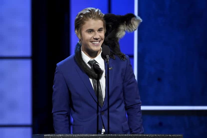 A monkey rests on Justin Bieber's shoulder as he speaks at the Comedy Central Roast of...