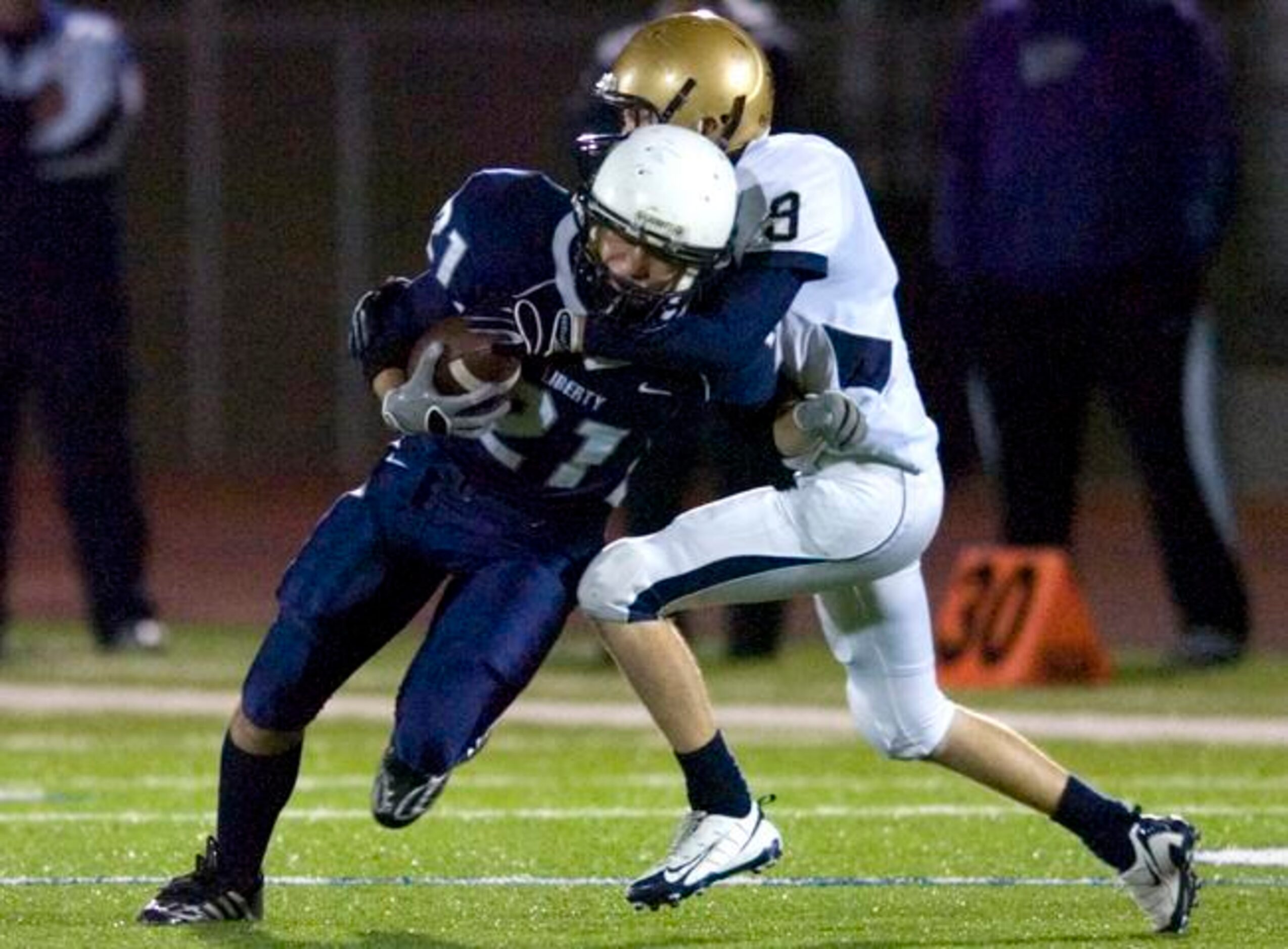 Argyle Liberty Christian senior wide receiver Adam Smith (21) is tackled by Arlington Grace...