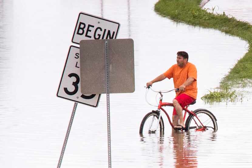 
Roberto Rodriguez tried to ride through a flooded section of Singleton Boulevard at Loop 12...