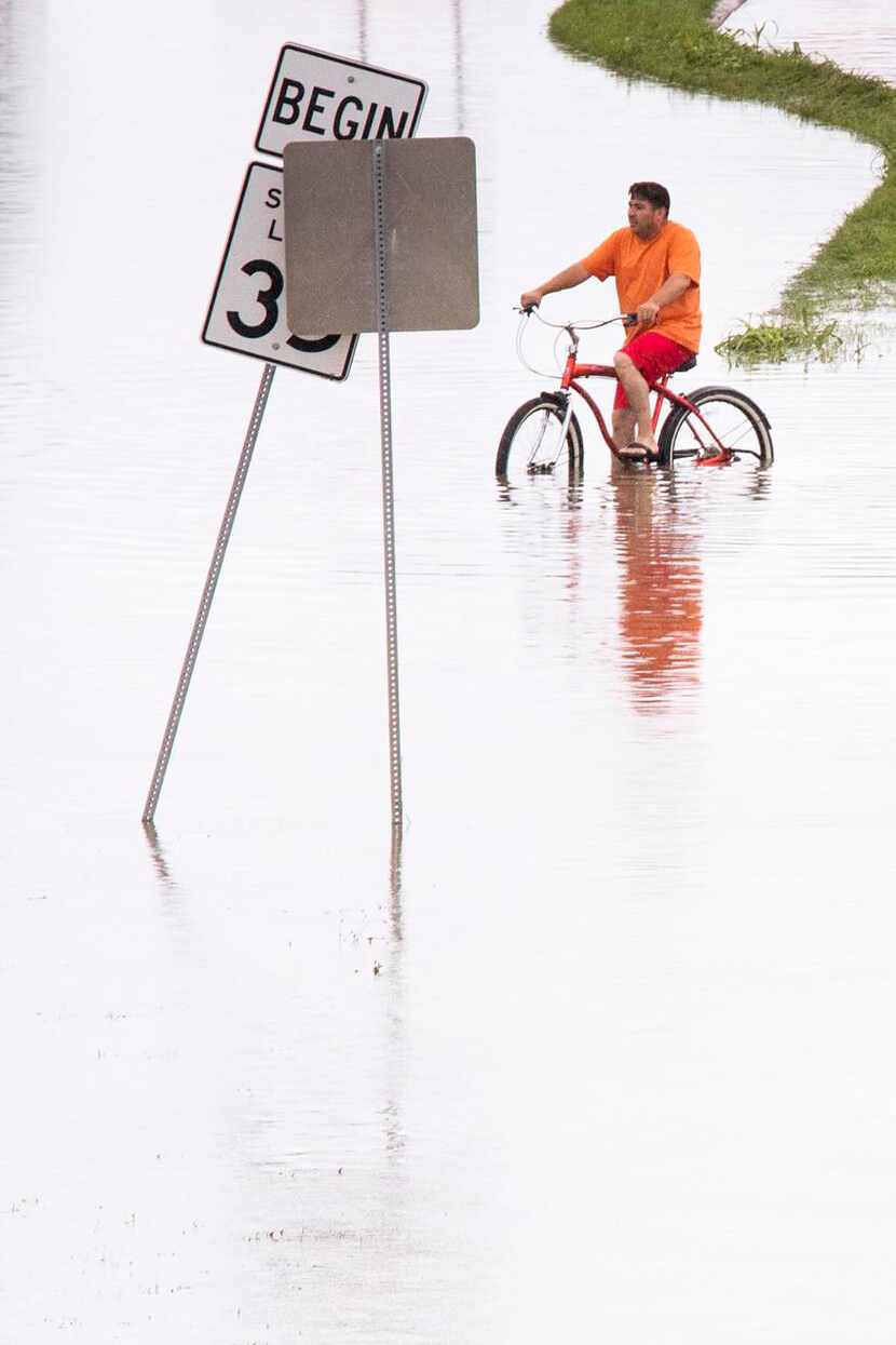 
Roberto Rodriguez tried to ride through a flooded section of Singleton Boulevard at Loop 12...
