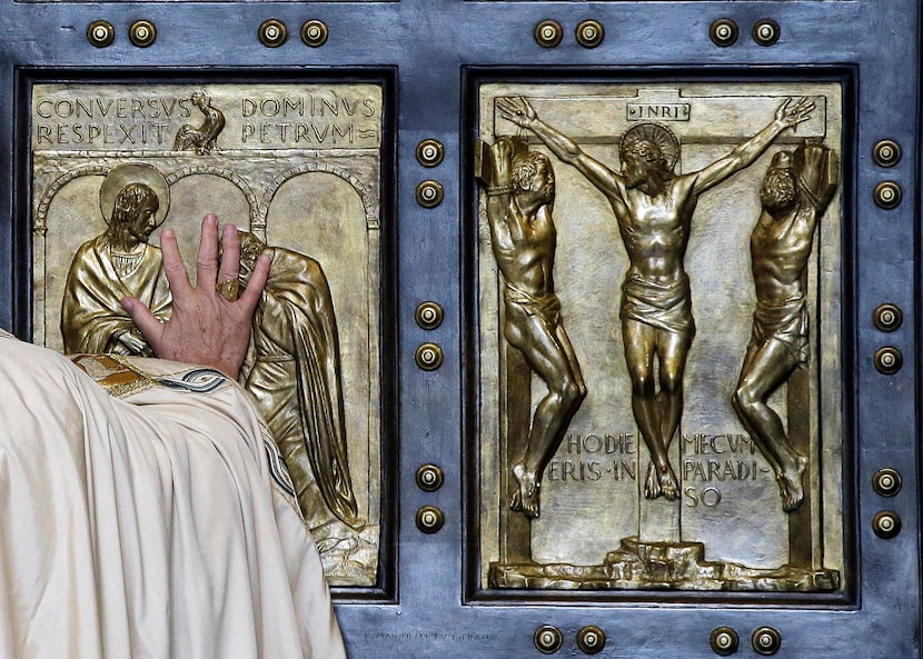 FILE - Pope Francis pushes open the Holy Door of St. Peter's Basilica, formally launching...