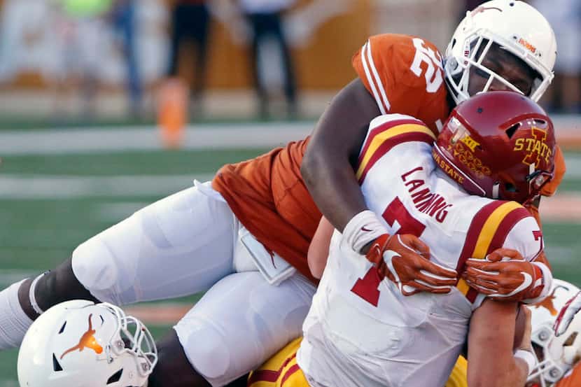 Iowa State quarterback Joel Lanning (7) is tackled by Texas' Malcolm Roach (32) and Jeffrey...