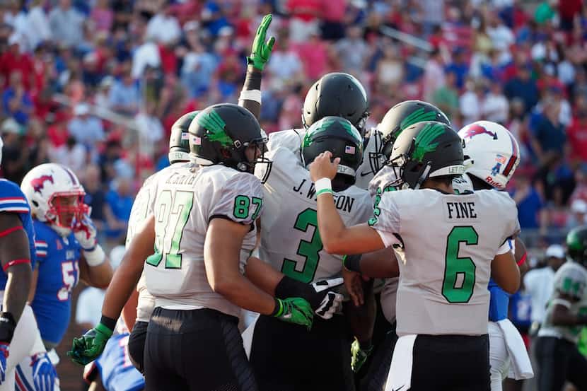 North Texas senior running back Jeffery Wilson (3) celebrates with his teammates after he...