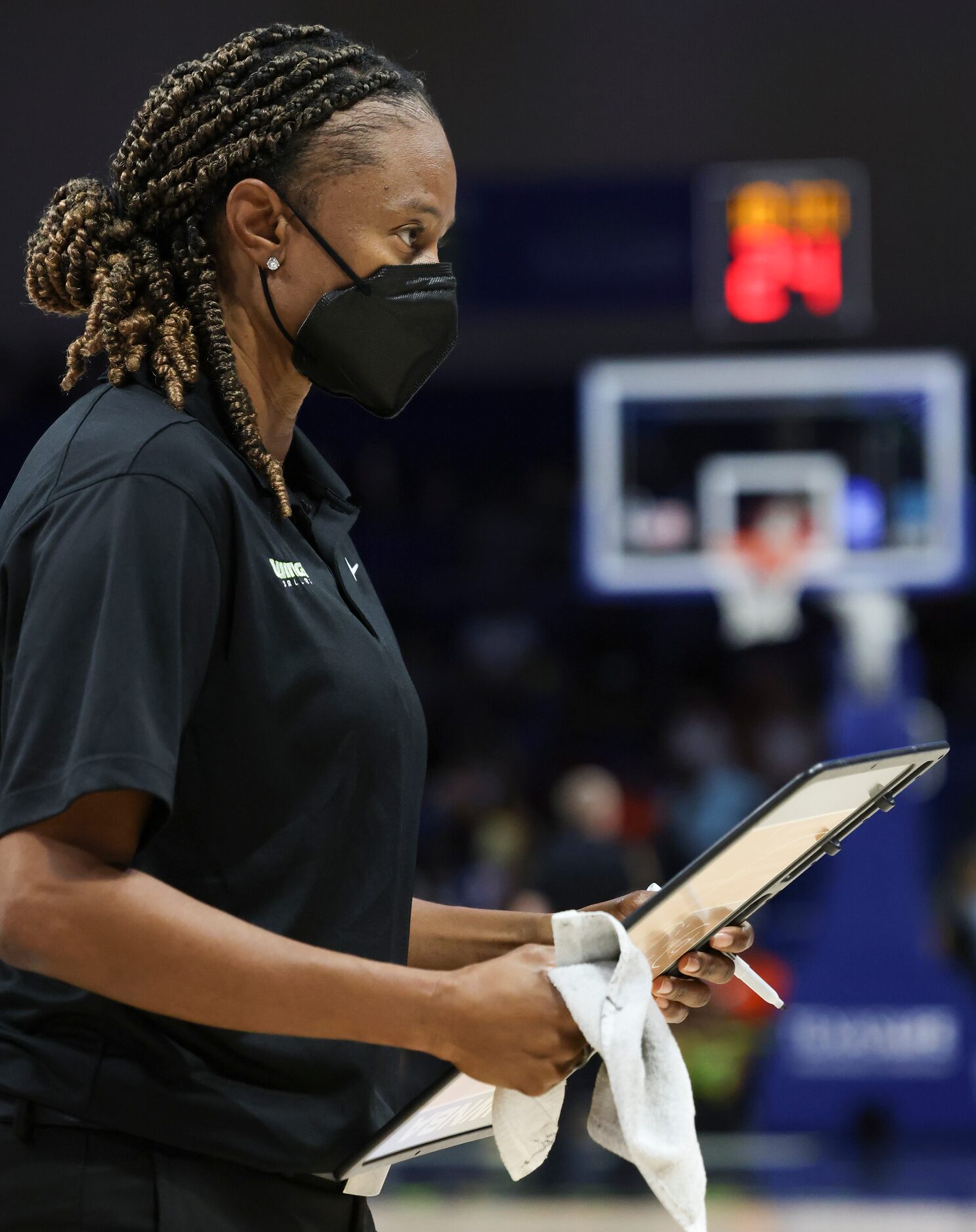 Vickie Johnson, Dallas Wings Head Coach, holds a white board, looking towards the Dallas...