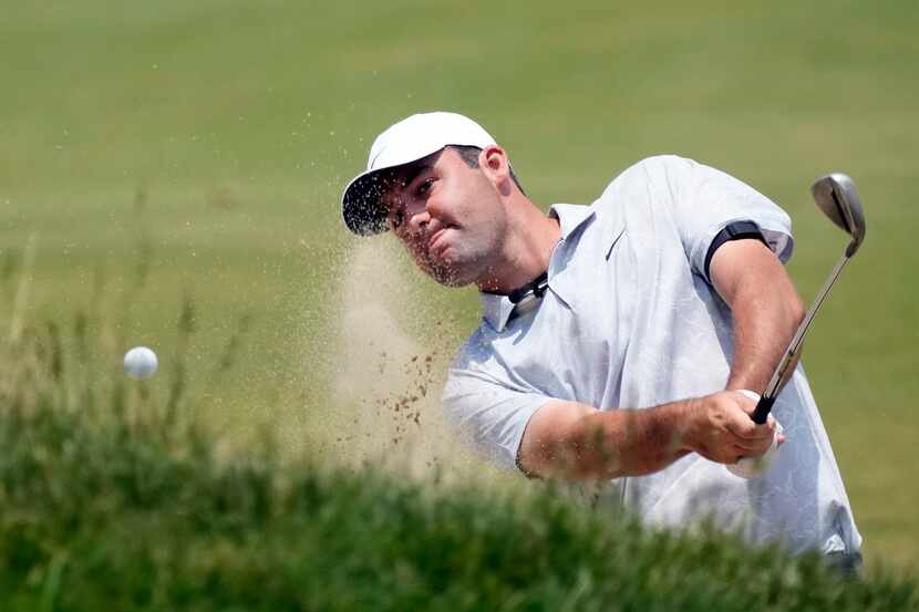 Scottie Scheffler hits from a bunker to the 17th green during a practice round of the U.S....