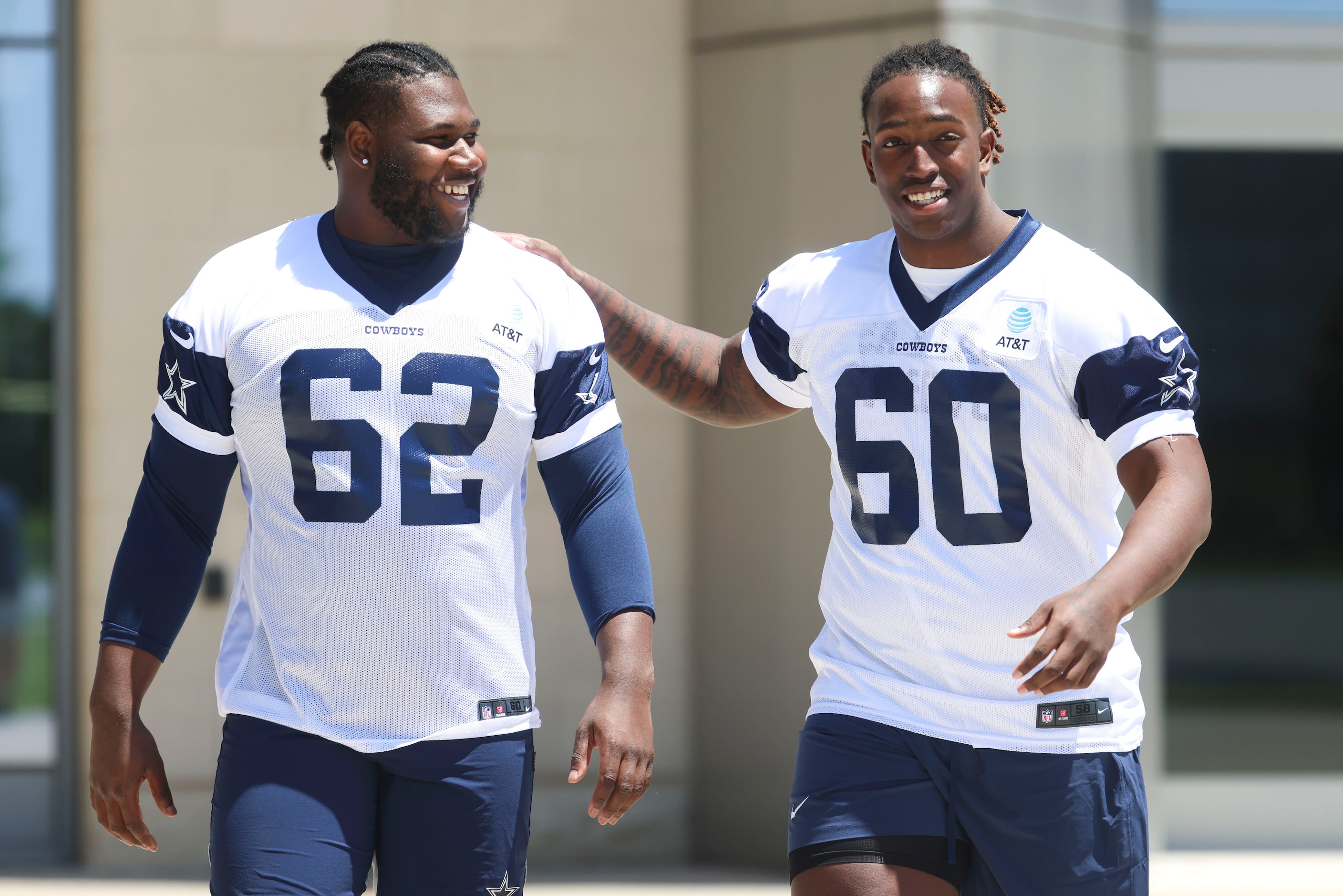 Dallas Cowboys offensive line Nathan Thomas (62) and Tyler Guyton (60) share a laugh as they...