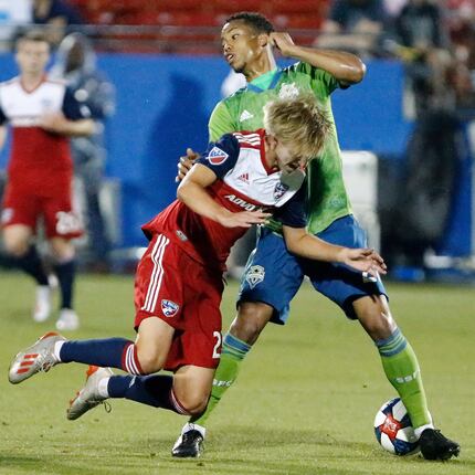 FC Dallas midfielder Thomas Roberts (23) is knocked off of his feet by Seattle Sounders...