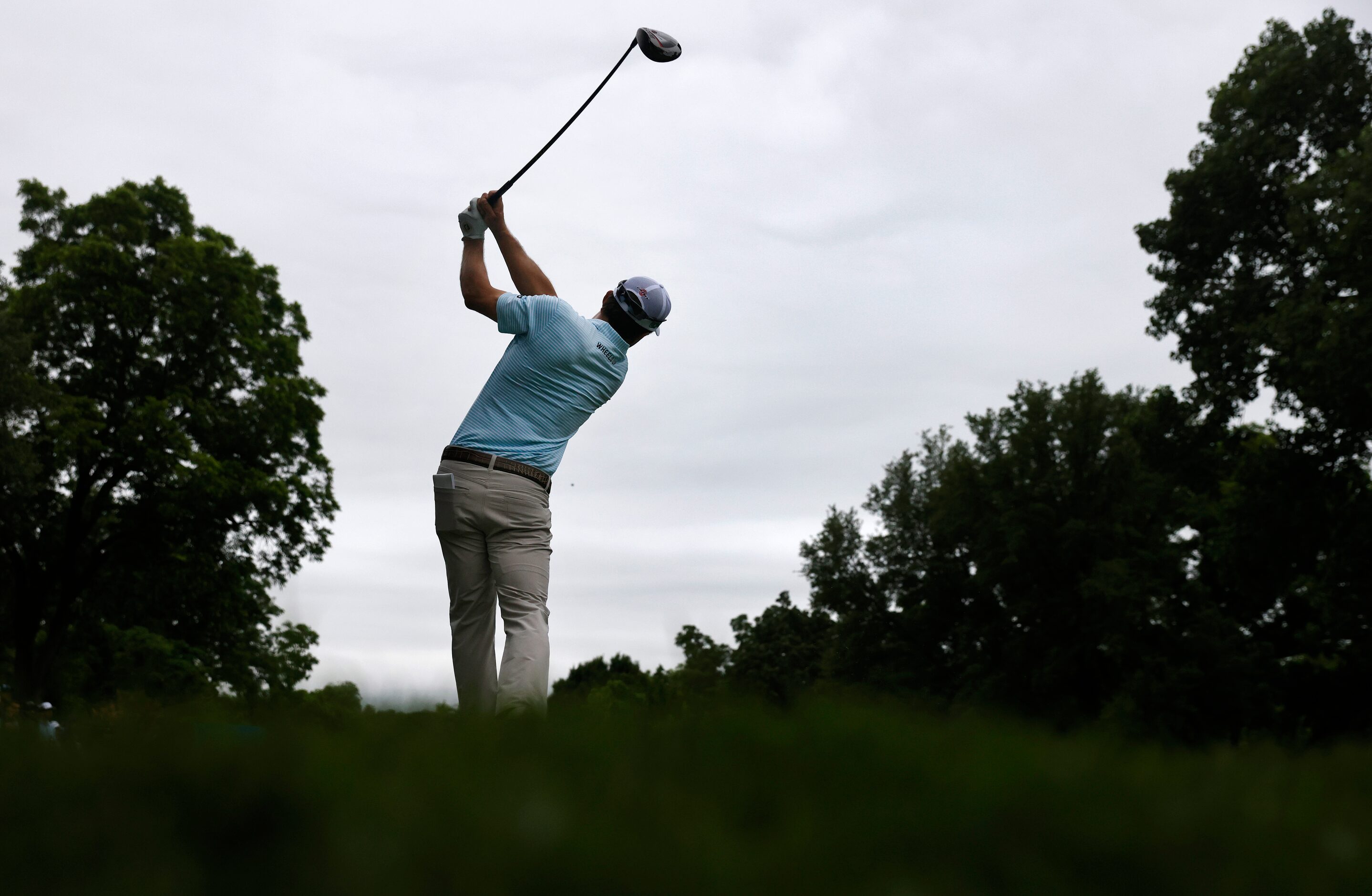 Professional golfer Kevin Kisner follows through on his tee shot on No. 9 during round two...