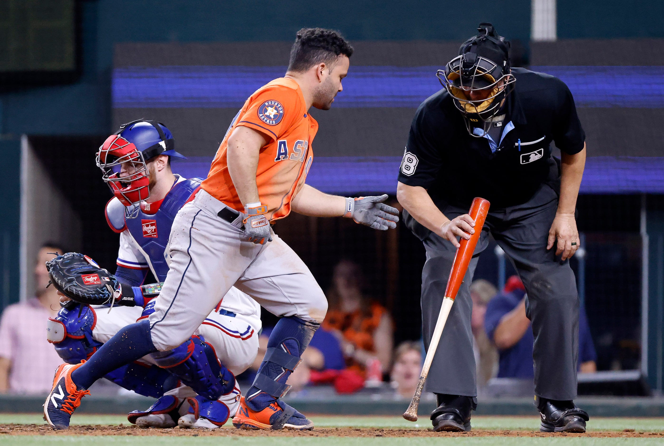 Umpire Doug Eddings (88) hands Houston Astros batter Jose Altuve (27) his bat back after he...