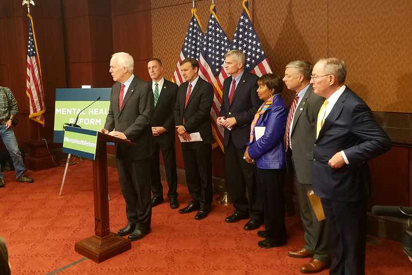 Texas Sen. John. Cornyn, flanked by Rep. Eddie Bernice Johnson and other lawmakers, cheered...